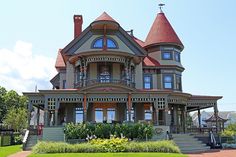 a large victorian style house with red roof