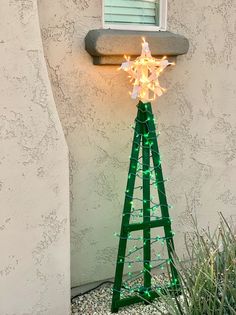 a lighted christmas tree in front of a house