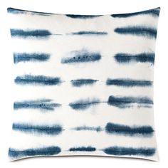 a blue and white pillow on a white background with watercolor stains in the middle