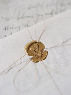 a close up of a piece of paper with a gold seal on it