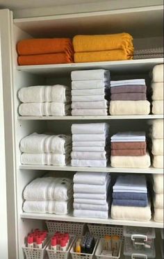 an organized closet with folded towels and baskets