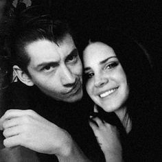 a man and woman hugging each other in black and white