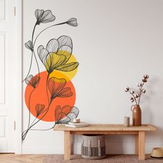 an orange and yellow flower wall decal on a white wall next to a wooden table