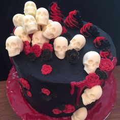 a black cake with red roses and skulls on it