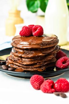 a stack of chocolate pancakes with raspberries on top