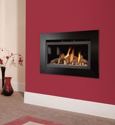 a fire place in a living room with red walls