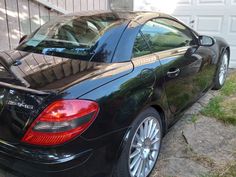 a black car parked in front of a house