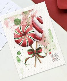 a watercolor painting of two lollipops on top of each other with a bow