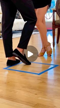 a man and woman standing on top of a hard wood floor next to each other