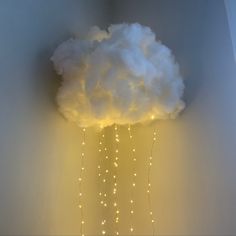 a cloud with lights hanging from it's sides in the corner of a room