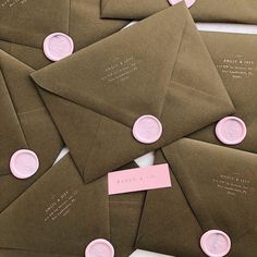 some brown envelopes with pink wax seals on them