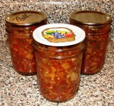 three jars filled with food sitting on top of a counter