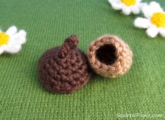 two crocheted baby booties sitting next to each other on a green surface