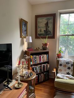 a living room filled with furniture and a flat screen tv sitting on top of a hard wood floor