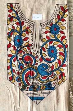 an embroidered piece of cloth with blue, red and yellow designs on the back of it