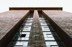 the side of an old brick building with windows and sky in the backgroud