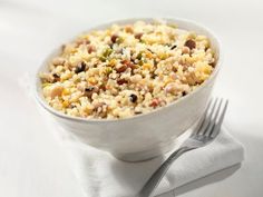 a white bowl filled with food next to a fork