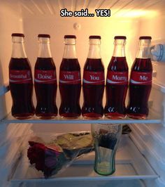 there are many bottles of soda in the refrigerator