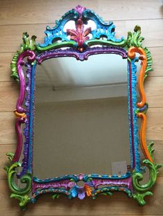 a colorful mirror sitting on top of a wooden floor