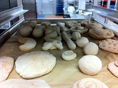 breads and pastries are lined up on a conveyor belt