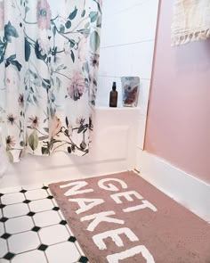 a bathroom with a rug that says make it written on the floor and shower curtain