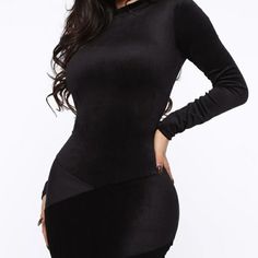 a woman posing in a black dress with her hands on her hips and looking at the camera