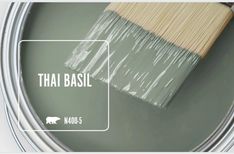 a paint can with the words thai basil on it and a brush in front of it