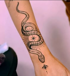 a woman's arm with a snake tattoo on it and an arrow in the middle