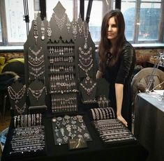 a woman standing next to a display of jewelry