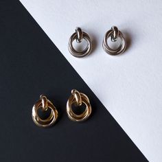 two pairs of earrings sitting next to each other