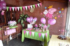 there is a table with pink and green balloons on it, along with other decorations