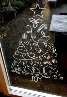 a christmas tree drawn in chalk on a window