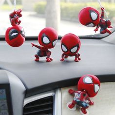 four spider - man figurines are hanging from the dashboard of a car,