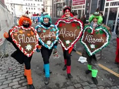 three people in costumes holding up heart shaped signs