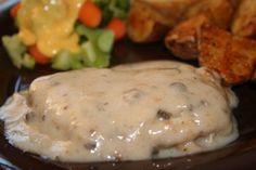 a plate topped with meat covered in gravy and vegetables