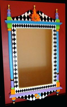 a brightly colored mirror on the wall in front of a red wall with black and white checkerboard