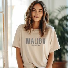 Malibu shirt, Malibu t shirt, State shirt, Cottagecore shirt, Malibu tee, University shirt, Aesthetic t-shirt, Inspirational t-shirt, Empowerment shirt, Birthday gift, Hippie shirt, Vintage shirt This classic unisex jersey short-sleeve tee fits like a well-loved favorite. Soft cotton and quality print make users fall in love with it repeatedly. These t-shirts have ribbed knit collars to bolster shaping. The shoulders have taping for a better fit over time.  💗100% Airlume combed and ringspun cotton     (fiber content may vary for different colors) 💗 Light fabric  💗Tear away label 💗Made to order (please allow 1-2 business days for your order to be completed) 💗Care instructions:      Wash inside out      Machine wash cold on a delicate cycle      No bleach/fabric softener      Tumble dry Relaxed Fit Graphic Tee Shirt With Letter Print, Everyday Short Sleeve Shirt With Text Print, Casual Tops With Sublimation Print In Relaxed Fit, Relaxed Fit Letter Print Graphic Tee, Graphic Tee With Sublimation Print In Relaxed Fit, Everyday Short Sleeve Shirt With Letter Print, Relaxed Fit Graphic Tee With Sublimation Print, Malibu Shirt, California Shirt