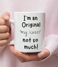 a person holding a coffee mug with the words i'm an original my knees not so much