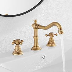 the faucet is running water from the sink in the bathroom, and it's shiny gold