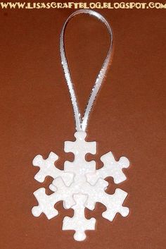 a white snowflake ornament hanging from a string on a cell phone