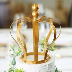 a white cake with gold crown decoration on top