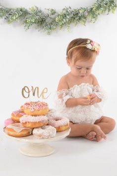 first birthday photoshoot with baby girl and a tower of donuts stacked on a plate. She is wearing a white lace romper and peachy flower headband. One Year Picture Ideas, Baby Girl 1st Birthday Photoshooting, Outdoor First Birthday, First Birthday Cake Smash Photoshoot, Happy Birthday Little One, Backdrop Inspiration, Cake Smash Photoshoot, Bday Pics, Smash Photoshoot