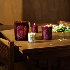 three candles sitting on top of a wooden table