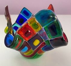 a multicolored glass vase sitting on top of a table