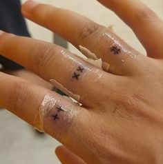 two fingers with small crosses on them are covered in clear plastic and have black ink