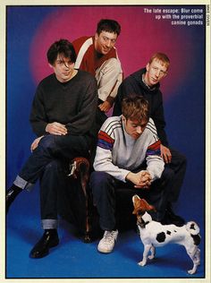 a group of young men sitting on top of a chair next to a small dog