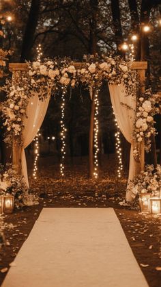 an outdoor wedding ceremony with candles and flowers on the aisle, decorated with white roses