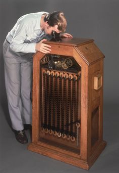 a woman leaning over an old fashioned radio with keys on the front and back sides