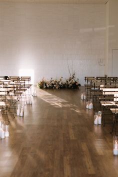 an empty room with rows of chairs and candles