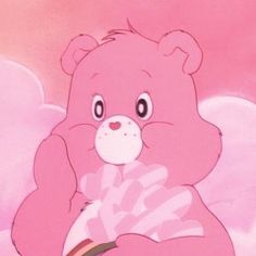 a pink teddy bear sitting on top of a cloud